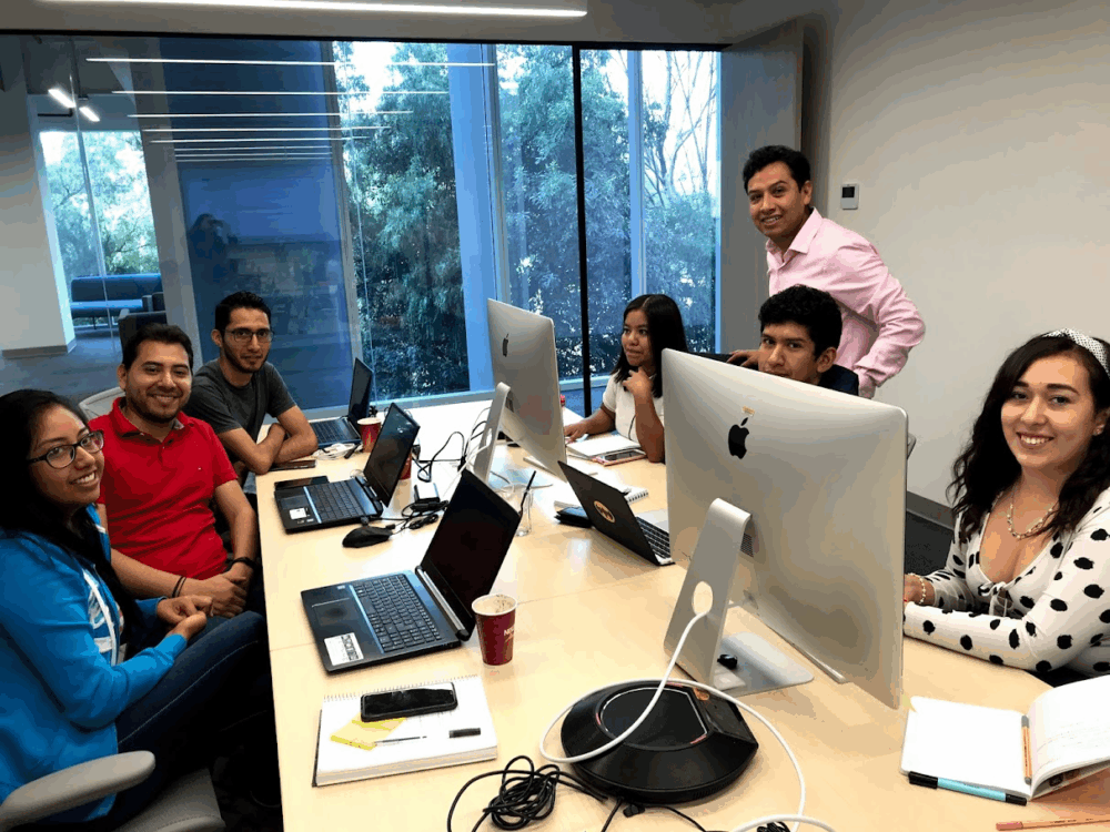 Un grupo de profesionales de QA trabajando en su laptop, simbolizando el crecimiento profesional en calidad de software.